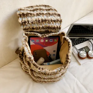 Makroansicht des geräumigen Innenfachs im gestreiften Tweed-Rucksack mit Inhalt
