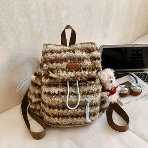Detail eines gestreiften Fleece-Rucksacks mit Lederlogo und süßem Plüsch-Hundeanhänger