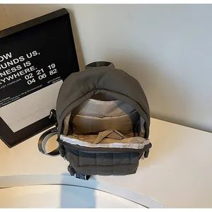 Vue détaillée du sac à dos matelassé vert olive montrant l'intérieur et les bretelles logo