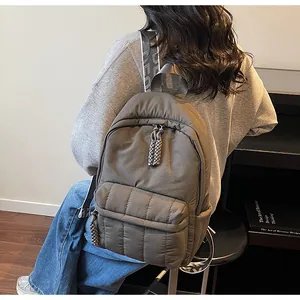 Détail du sac à dos en nylon marron foncé matelassé avec bretelles tissées élégantes
