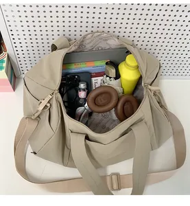Top view of spacious beige yoga bag interior filled with laptop, bottle and daily essentials