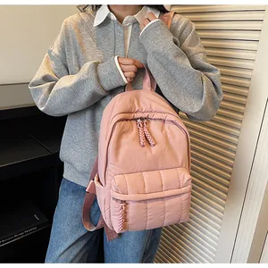 Vue détaillée du sac à dos en nylon matelassé rose avec bretelles jacquard lettrées