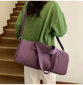 Lifestyle shot of a purple large capacity gym bag with a shoulder strap on stairs