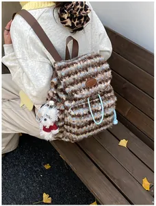 Makroansicht des Plüsch-Rucksacks mit Karomuster, Kordelzug und Hunde-Anhänger