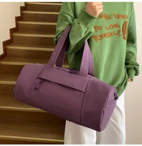 Detail of the side zipper pocket and nylon texture on the purple cylinder gym bag