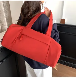 Detailed side view of the red nylon travel tote featuring side zipper pocket and dual handles