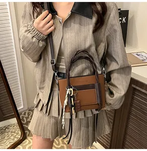 Close-up of woven rope handle and chic brown leather patchwork detail on crossbody bag
