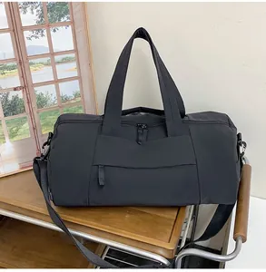 Close-up of black nylon travel gym bag with dual handles and detachable shoulder strap