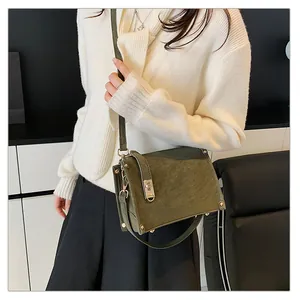 Détail du sac boîte vert foncé mat avec fermoir rotatif doré et accents de rivets