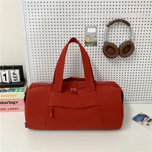 Minimalist red cylindrical gym tote bag with durable nylon handles and spacious compartments