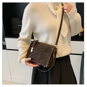 Détail du sac boîte vintage marron foncé avec fini mat et fermoir doré rotatif