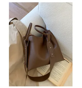 Detail view of large brown lychee pattern bucket bag with rivets on soft leather texture