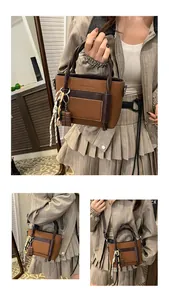 Detail of a brown PU leather handbag featuring woven rope handles and a chocolate pendant