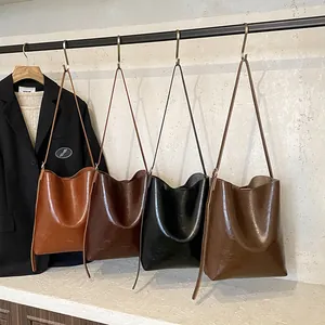 Set of four minimalist leather bucket bags in caramel, coffee, black, and olive green