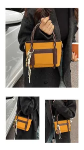Detail of crossbody bag featuring ginger lychee leather texture and woven rope handle charm