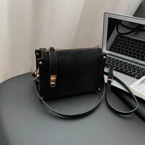 Sac à épaule noir minimaliste avec détails dorés dans un cadre de vie moderne