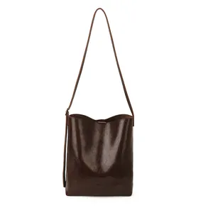 Deep brown vintage leather bucket bag with glossy finish and slim shoulder strap