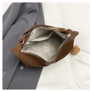 Large brown tote bag with spacious interior compartment and plush bear charm detail