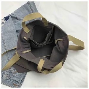 Detailed top view of dark grey canvas tote interior with khaki straps and zip pocket