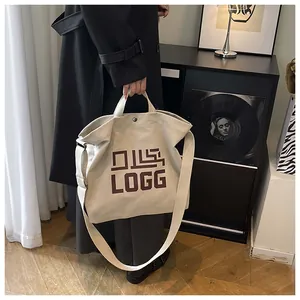 Detail of cream canvas tote bag showing reinforced handles and secure metal snap closure
