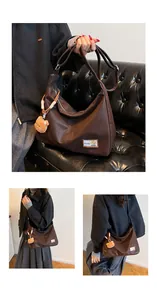 Close-up of deep brown tote bag textured leather with fashion bear label and plush charm