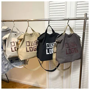 Detail view of canvas tote bags in four colors with adjustable straps and logo print