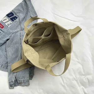 Khaki canvas tote bag featuring large capacity interior with zip pocket and strap