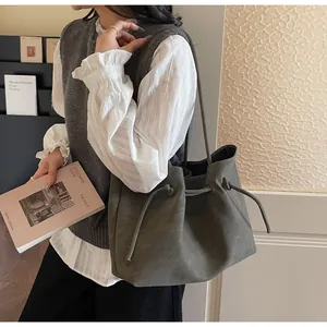 Nahaufnahme der grauen Shopper-Tasche mit seitlichem Kordelzug und breitem Schultergurt