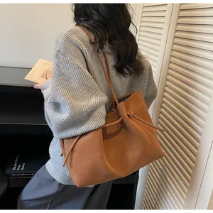 Nahaufnahme der braunen Retro-Shopper-Tasche mit Kordelzug-Knoten und matter Ledertextur