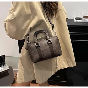 Detail showing dark brown woven texture of the handbag against a beige trench coat