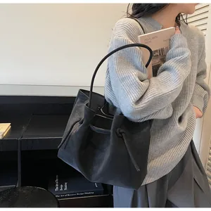 Detailaufnahme der mattschwarzen Beuteltasche mit elegantem Kordelzug und Trageriemen