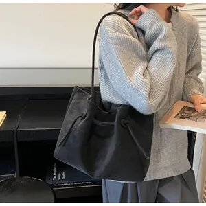 Nahaufnahme der mattschwarzen Leder-Tote-Bag mit langen Riemen an einem Modell
