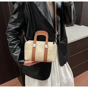 Detail view of retro woven tote bag with brown leather trim and silver metal buckles