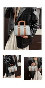 Detail of light blue textured fabric handbag with brown leather accents and silver hardware