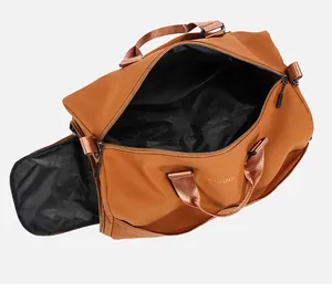 Detail of caramel travel bag showing open main compartment and side shoe pocket