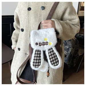 Détail du sac à dos lapin en peluche avec longues oreilles et broderie HAPPY DAYS blanche