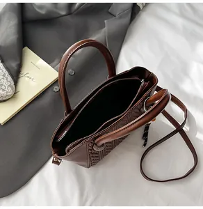 Detail der braunen Webstruktur und des geräumigen Innenfutters der Retro-Handtasche