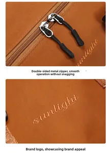 Detail of dual metal zippers and Sunlight embroidery on brown travel bag fabric