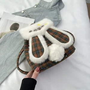 Détail du sac à dos oreilles de lapin avec motif à carreaux et peluche blanche