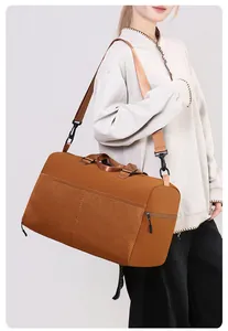 Detail view of the brown travel bag with mesh pocket and adjustable shoulder strap