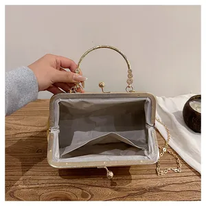 Macro view of gold evening bag with grey herringbone lining and metal handle detail