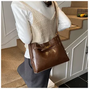 Vue détaillée du sac à bandoulière rétro en cuir marron foncé avec fermoir rotatif