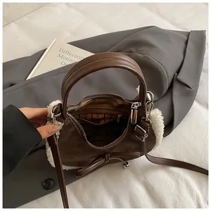 Brown suede crescent bag with white faux fur trim and bow detail for winter fashion