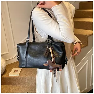Detail view of black oil wax leather tote with silver hardware and dachshund charm