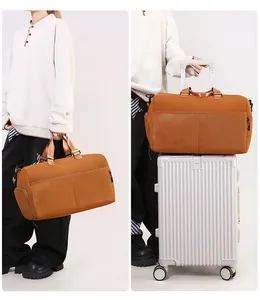 Detail view of brown travel bag secured onto silver luggage handle for easy transport