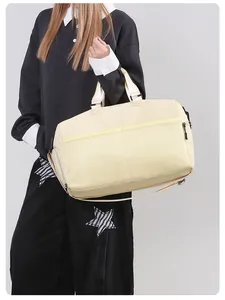 Detail view of multifunctional beige travel bag with mesh pocket and detachable shoulder strap