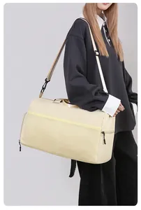 Beige multi-functional travel bag with mesh pocket shown on shoulder by model