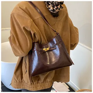 Détail du sac vintage marron avec finition brillante et fermoir rotatif en métal doré
