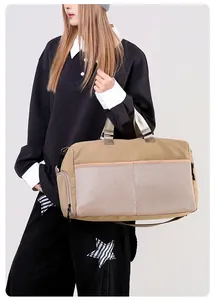 Detail view of khaki travel bag showing front mesh pocket and reinforced handles