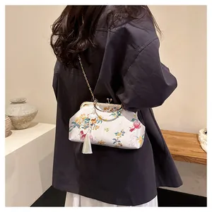 Detail of white silk embroidery bag featuring floral koi patterns and a long tassel